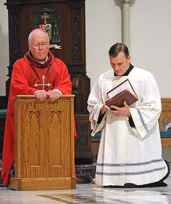 Bishop Richard Malone and Father Ryszard Biernat pray during the Solemn Celebration of the Lord's Passion on Good Friday at St. Joseph Cathedral. (Dan Cappellazzo/Staff Photographer)